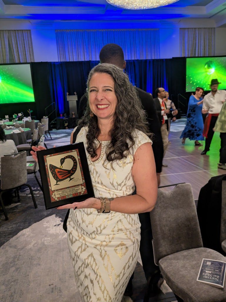 Katie Sciurba receiving a book award from NAME.