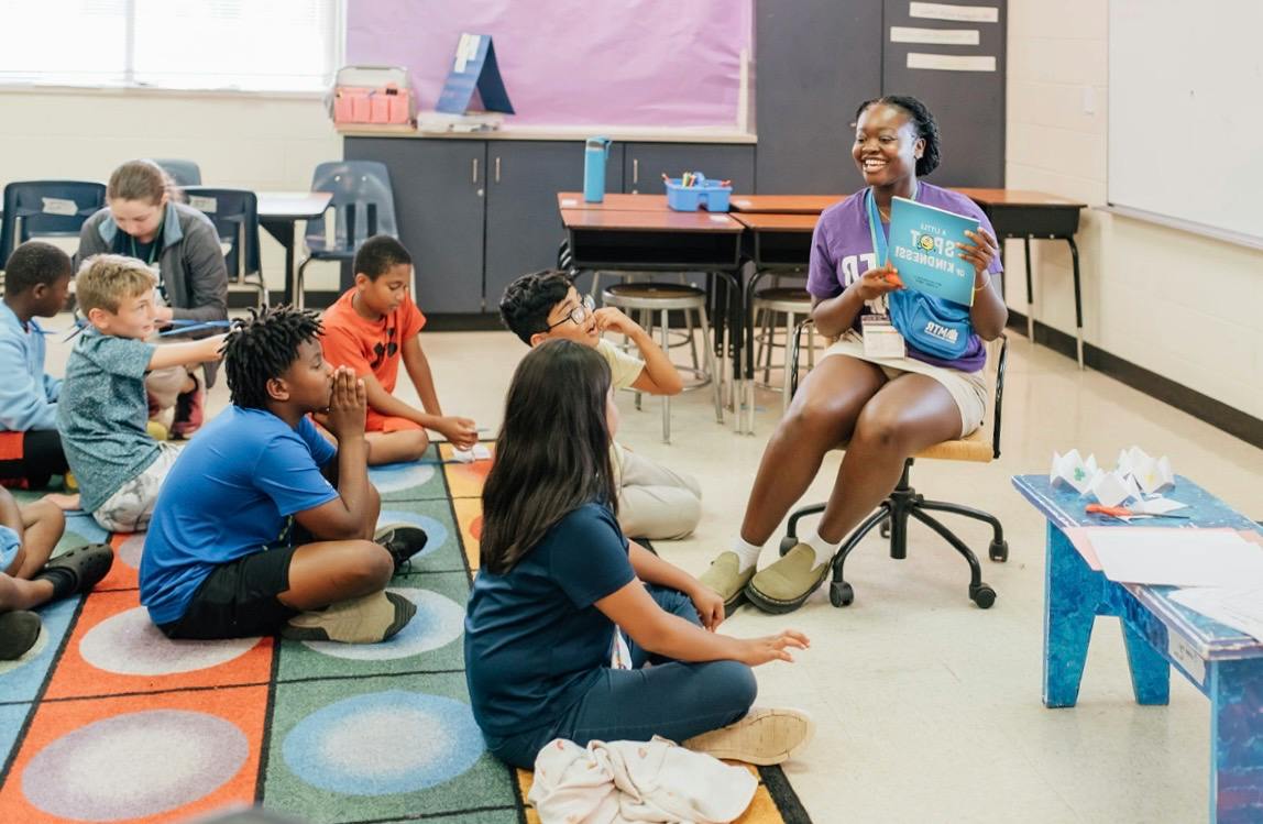 Ikeoluwa Ojo reads to students in a classroom