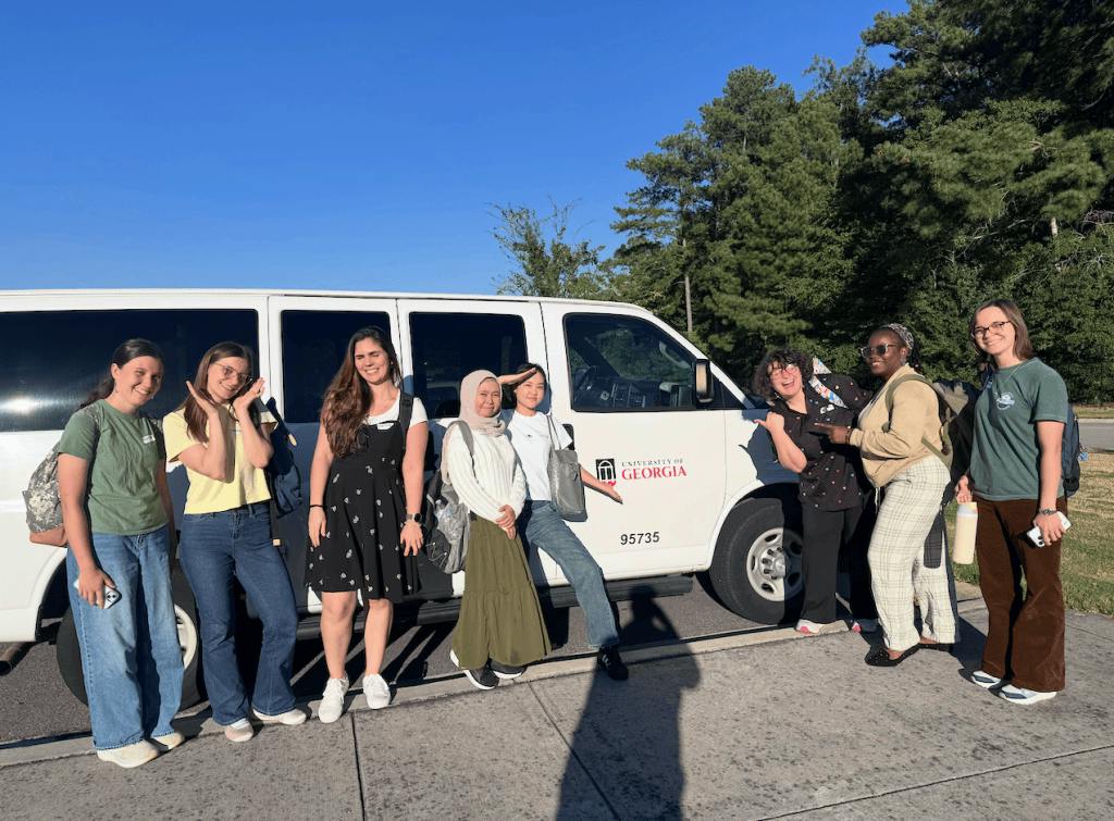 UGA students taking Dave Chiesa's service-learning course pose in front of a UGA van.